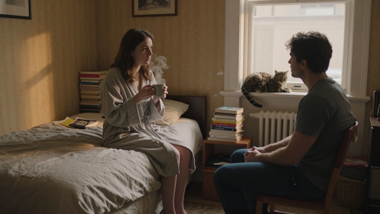 A woman and man sit quietly in a modest East London flat, sharing tea in soft lamplight.